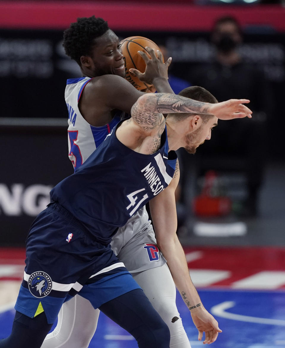 Detroit Pistons forward Sekou Doumbouya (45) is fouled by Minnesota Timberwolves forward Juancho Hernangomez (41) during the second half of an NBA basketball game, Tuesday, May 11, 2021, in Detroit. (AP Photo/Carlos Osorio)