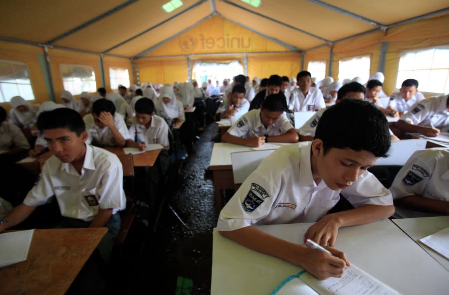 Students attend a class in a makeshift classroom set up by UNICEF on Monday Oct. 5, 2009 in Padang, Indonesia. Hundreds of children went back to class Monday in schools set up in tents in Indonesia’s earthquake zone to get counseling on the loss of loved ones and homes, as authorities tried to restore normalcy after the disaster.(AP Photo/Wong Maye-E)