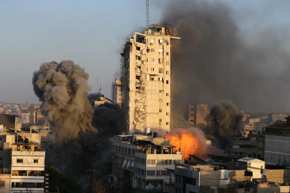 <p>Smoke and flames rise from a tower building as it is destroyed by Israeli airstrikes in Gaza City</p> (Reuters)