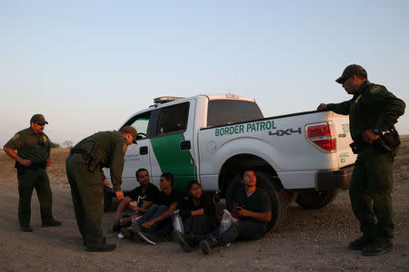 Border patrol agents apprehend immigrants who illegally crossed the border from Mexico into the U.S. in the Rio Grande Valley sector, near McAllen, Texas, U.S., April 2, 2018. REUTERS/Loren Elliott