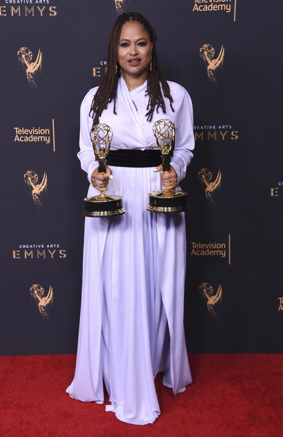 FILE - Ava DuVernay, poses in the press room with the awards for outstanding documentary or nonfiction special, and for outstanding writing for nonfiction program for "13th" during night one of the Creative Arts Emmy Awards in Los Angeles on Sept. 9, 2017. DuVernay, who created the TV series “Queen Sugar” hired Cierra Glaude to work on the Oscar-nominated 2014 film “Selma” as well as her CBS pilot “For Justice.” (Photo by Richard Shotwell/Invision/AP, File)