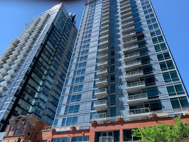 Paving stones were blown off the balcony of a residential tower in the Beltline on Wednesday. There were no injuries but several vehicles were damaged. (Mike Symington/CBC - image credit)
