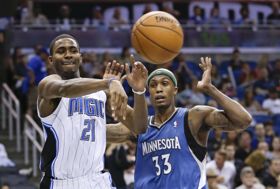 Orlando Magic's Maurice Harkless (21) passes the ball around Minnesota Timberwolves' Dante Cunningham (33) during the second half of an NBA basketball game in Orlando, Fla., Saturday, April 5, 2014. Orlando won 100-92. (AP Photo/John Raoux)