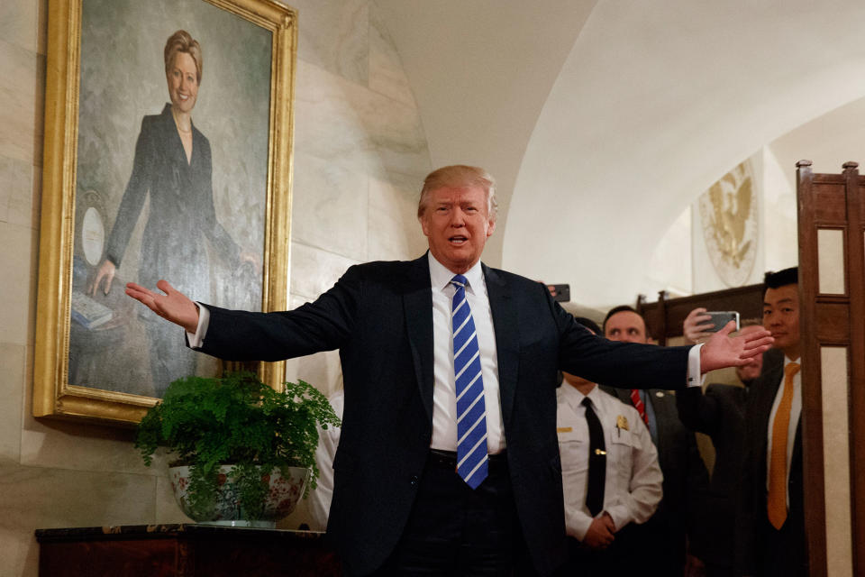 Trump poses in front of a Hillary painting