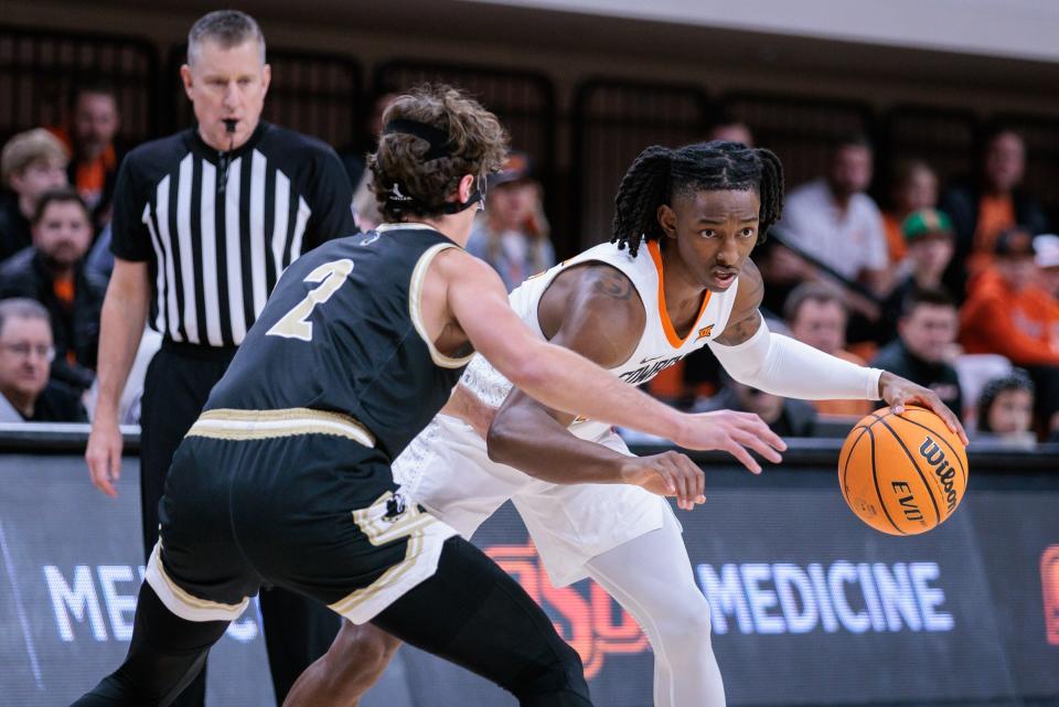 Dec 20, 2023; Stillwater, Oklahoma, USA; Oklahoma State Cowboys guard Javon Small (12) looks to get around Wofford Terriers guard Dillon Bailey (2) during the second half at Gallagher-Iba Arena. Mandatory Credit: William Purnell-USA TODAY Sports