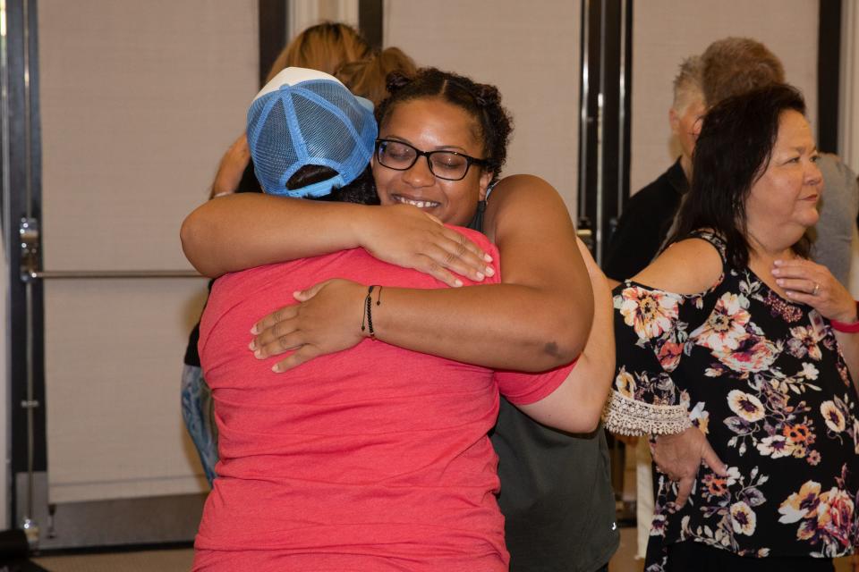 Andrea Alvarez enjoys a hug from a fellow cancer survivor.