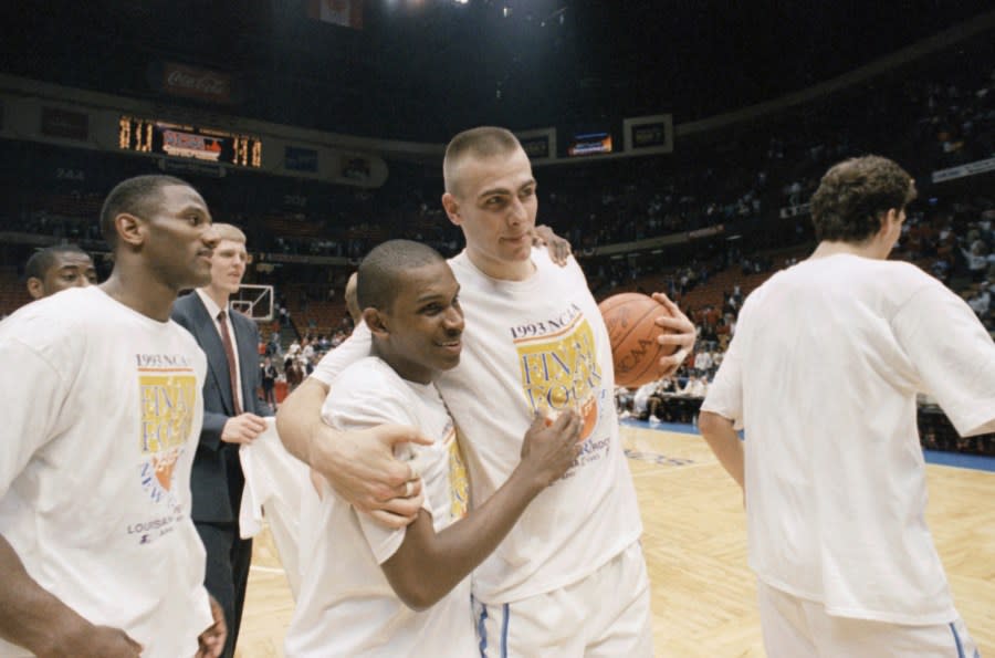 North Carolinas Eric Montross, right, celebrates with teammate Donald Williams, center left, after the Tarheels beat Cincinnati 75-68 in overtime in NCAA East Regional Championship game at the Meadowlands Arena, Sunday, March 28, 1993, East Rutherford, N.J. Williams hit two 3-points shots in overtime to send North Carolina to the Final Four in New Orleans. The player on the left is unidentified. (AP Photo/Bill Kostroun)