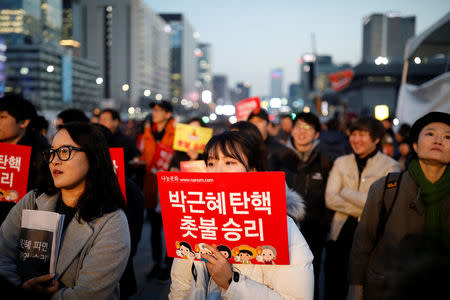 People attend a rally calling for impeached President Park Geun-hye's arrest in central Seoul, South Korea, March 10, 2017. The sign reads "Park Geun-hye is impeached, We won". REUTERS/Kim Hong-Ji