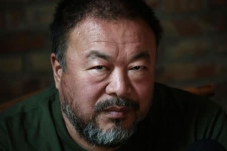 Dissedent Chinese artist Ai Weiwei reacts during a group interview at his studio in Beijing May 22, 2013. REUTERS/Petar Kujundzic