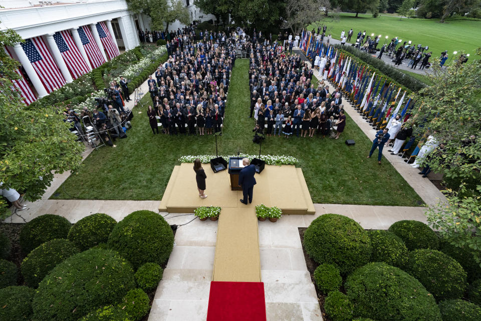 In this Sept. 26, 2020, photo President Donald Trump, center, stands with Judge Amy Coney Barrett as they arrive for a news conference to announce Barrett as his nominee to the Supreme Court, in the Rose Garden at the White House in Washington. Former New Jersey Gov. Chris Christie watches from fourth row from front on far right. (AP Photo/Alex Brandon)