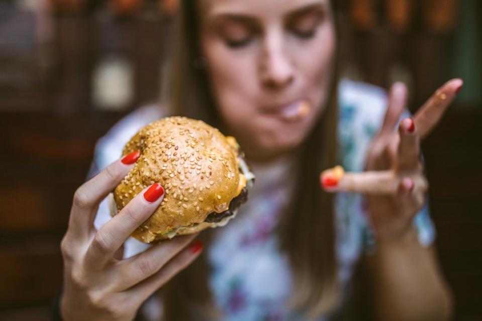 Mujer comiendo una hamburguesa