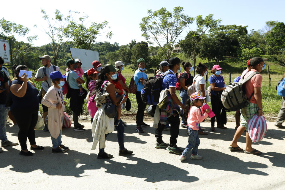 Migrants who are part of a caravan hoping to reach the United States, line up as they wait to have their documents checked in Corinto, Honduras, Saturday, Jan. 15, 2022. (AP Photo/Delmer Martinez)