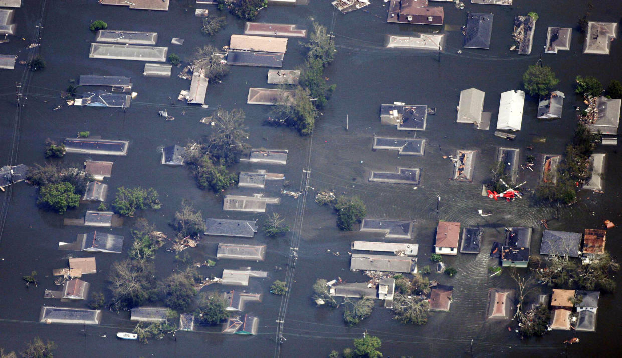 A Coast Guard helicopter passes over a flooded neighborhood east of downtown New Orleans, Aug. 30, 2005