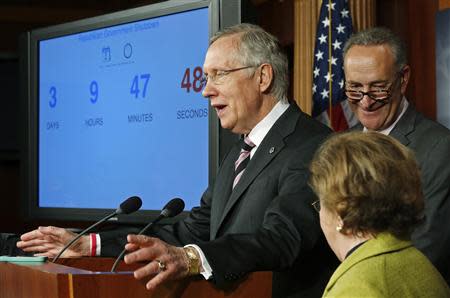 U.S. Senate Majority Leader Harry Reid (D-NV) speaks next to a screen showing a clock counting down to a government shutdown, at a news conference with fellow Democrats Senator Chuck Schumer (D-NY) (R) and Senator Barbara Mikulski (D-MD) (bottom) after the Senate voted to pass a spending bill in an attempt to avoid the shutdown, sending the issue back to the House of Representatives, at the U.S. Capitol in Washington September 27, 2013. REUTERS/Jonathan Ernst (UNITED STATES - Tags: POLITICS BUSINESS)