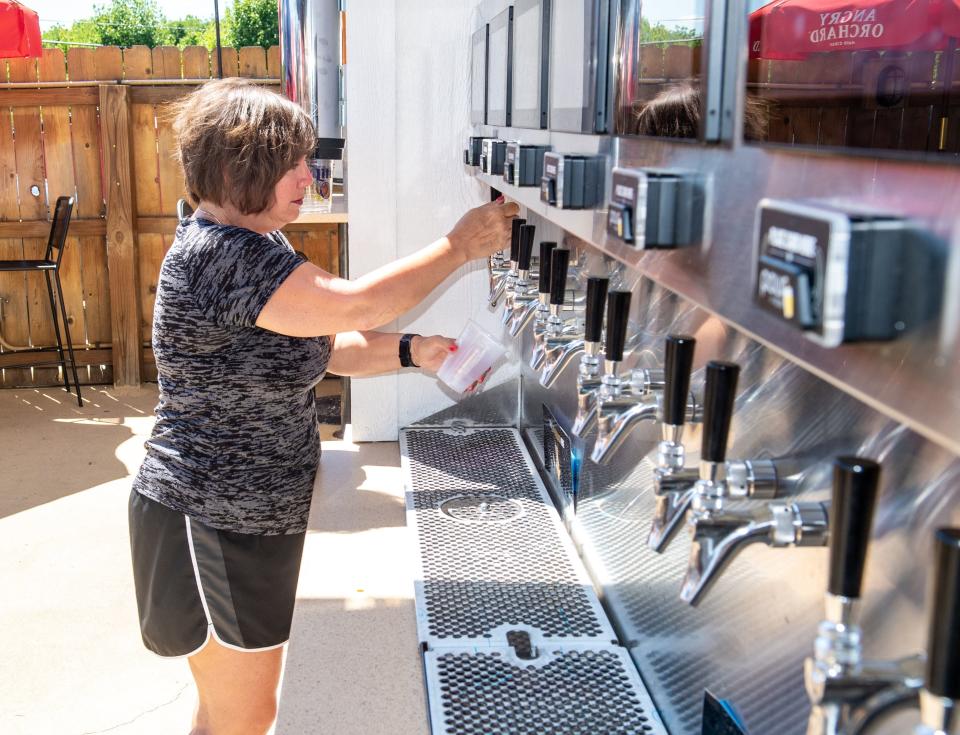 Pickerington resident Linda Jones uses the self-pour beverage wall at Cardo's Pizza & Tavern on June 27.