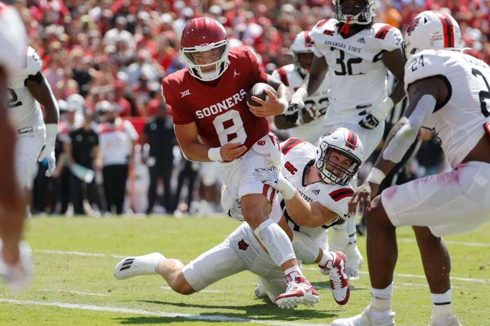 Oklahoma’s <a class="link " href="https://sports.yahoo.com/ncaaf/players/299857/" data-i13n="sec:content-canvas;subsec:anchor_text;elm:context_link" data-ylk="slk:Dillon Gabriel;sec:content-canvas;subsec:anchor_text;elm:context_link;itc:0">Dillon Gabriel</a> (8) runs past Arkansas State’s Charles Willekes to score a touchdown during a college football game between the University of Oklahoma Sooners (OU) and the Arkansas State Red Wolves at Gaylord Family-Oklahoma Memorial Stadium in Norman, Okla., Saturday, Sept. 2, 2023.