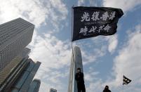 An anti-government protester waves a flag during a protest at Edinburgh Place in Hong Kong