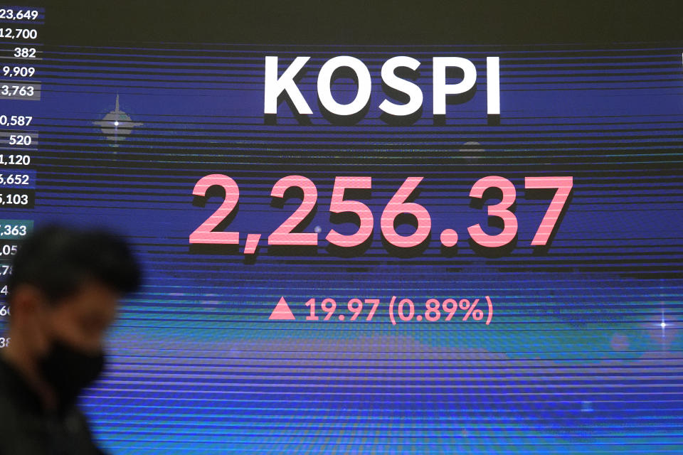 A huge screen shows the Korea Composite Stock Price Index (KOSPI) as a man walks after the opening ceremony of the 2023 trading year at the Korea Exchange in Seoul, South Korea, Monday, Jan. 2, 2023. Shares began the year mixed on Monday, with most markets closed for New Year holidays. (AP Photo/Lee Jin-man)