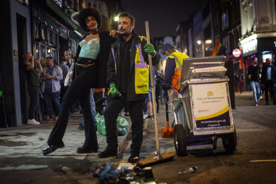 A woman poses with a street cleaner in Soho last weekend (PA)