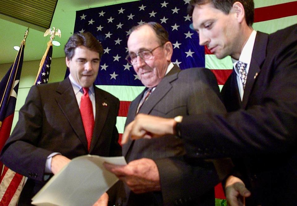 Texas Gov. Rick Perry, his father Ray Perry and France Consul General Denis Simonneau look over Ray Perry’s certificate he received May 21, 2002, for his World War II service. A “Liberation of France” ceremony was held at the Dallas VA Medical Center. The French consul passed out thank-you certificates to veterans.