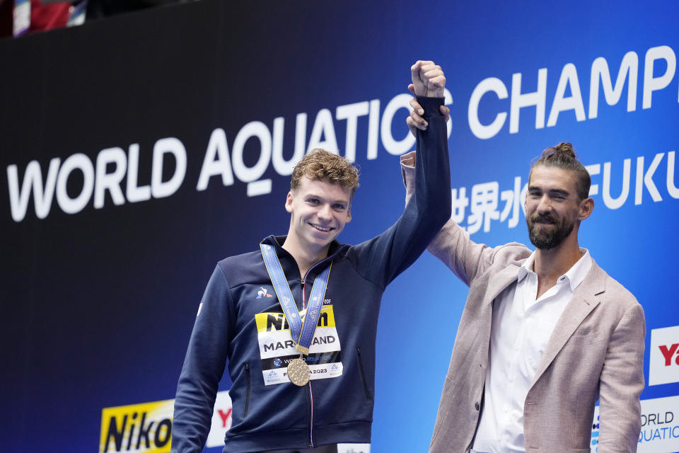 Michael Phelps (à droite) a été appelé lors de la course de dimanche au Japon et a célébré avec Leon Marchand après sa chute record.  (AP/Eugène Hoshiko)