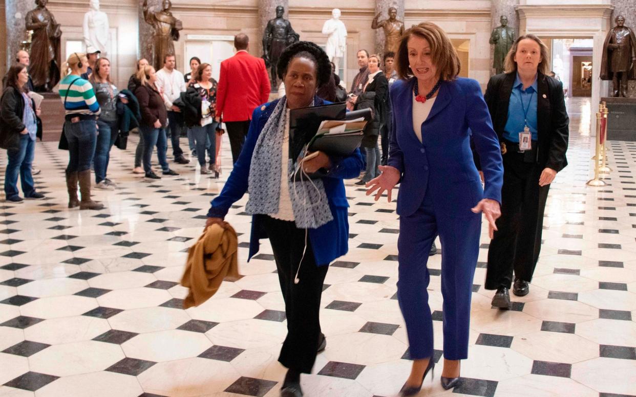 US Speaker of the House Nancy Pelosi (C R)) and congresswoman Sheila Jackson Lee (C L) walk to the House Chambers, to vote on blocking the national emergency over border situation - AFP