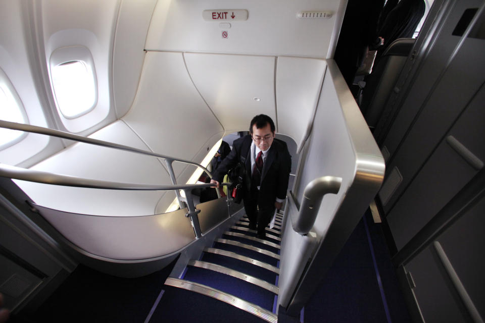 A visitor walks up the stairs to the second floor on the new Boeing 747-8 Intercontinental before delivery by Boeing to Lufthansa Tuesday, May 1, 2012, in Everett, Wash. Lufthansa is the launch customer for the Intercontinental and will start service with the airplane between Frankfurt, Germany and Washington, D.C. The 747-8 Intercontinental is a stretched, updated version of the iconic 747 and is expected to bring double-digit improvements in fuel burn and emissions over its predecessor, the 747-400, and generate 30 percent less noise. Boeing delivered the first 747-8 Intercontinental to a private customer in February, more than a year after originally planned. (AP Photo/Elaine Thompson)