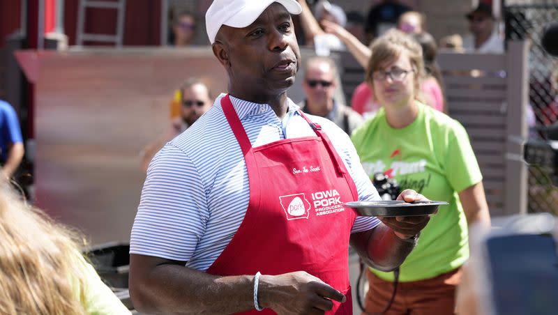 Republican presidential candidate Sen. Tim Scott, R-S.C., serves pork samples after working the grill at the Iowa Pork Producers tent at the Iowa State Fair, Tuesday, Aug. 15, 2023, in Des Moines, Iowa.