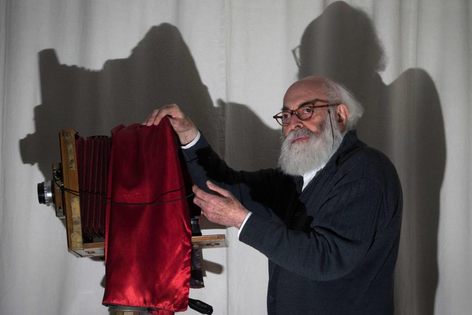 Adolfo Kaminsky poses with a Lorillon camera at his home in Paris - JOEL SAGET/AFP via Getty Images