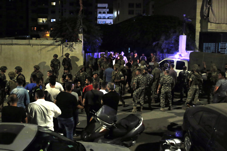 Lebanese security stand at the site where an Israeli drone was said to have crashed in a stronghold of the Lebanese Hezbollah group, in a southern suburb of Beirut, Lebanon, Sunday, Aug. 25, 2019. A Hezbollah official said Sunday that an Israeli drone went down over the Lebanese capital of Beirut and another exploded in the air, amid regional tensions between Israel and Iran. (AP Photo/Bilal Hussein)