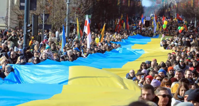 La gente camina con una bandera ucraniana gigante para protestar contra la invasi&#xf3;n rusa de Ucrania en Vilna, Lituania, el 11 de marzo de 2022.