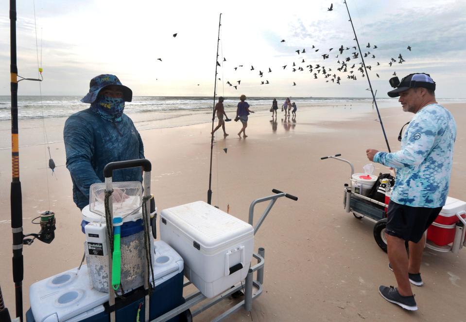 A pair of fishermen get ready to try their luck near the Daytona Beach Pier on Wednesday. Officials say hazardous rip current conditions that played havoc over the holiday weekend will continue throughout this week.