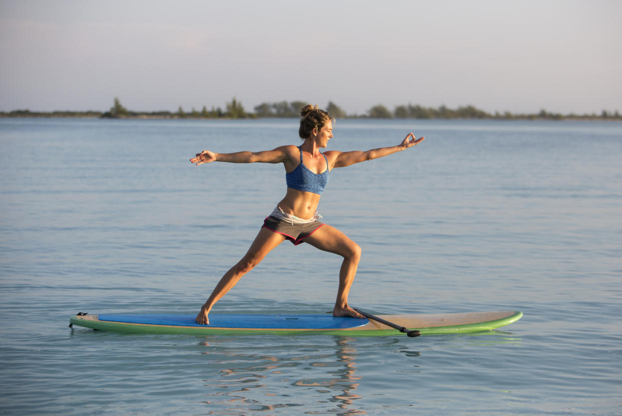 Yoga auf dem Stand-Up-Paddling-Board erfordert Balance. - Copyright: Getty Images/JMichl