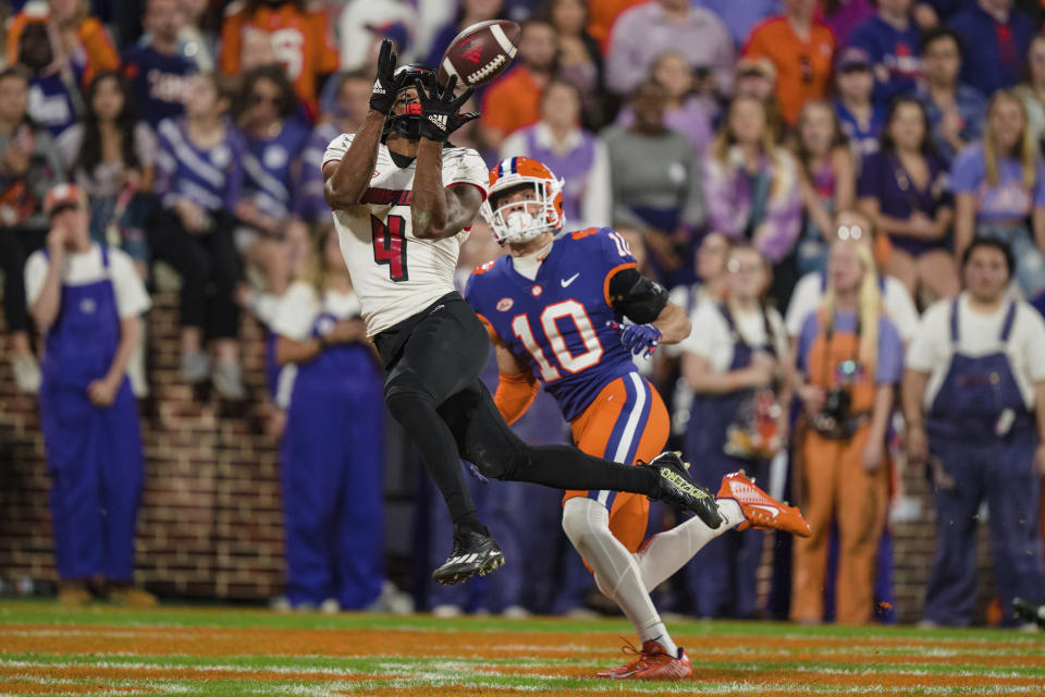 Louisville wide receiver Braden Smith (4) makes a touchdown catch while defended by Clemson cornerback Jeadyn Lukus (10) in the second half of an NCAA college football game, Saturday, Nov. 12, 2022, in Clemson, S.C. (AP Photo/Jacob Kupferman)