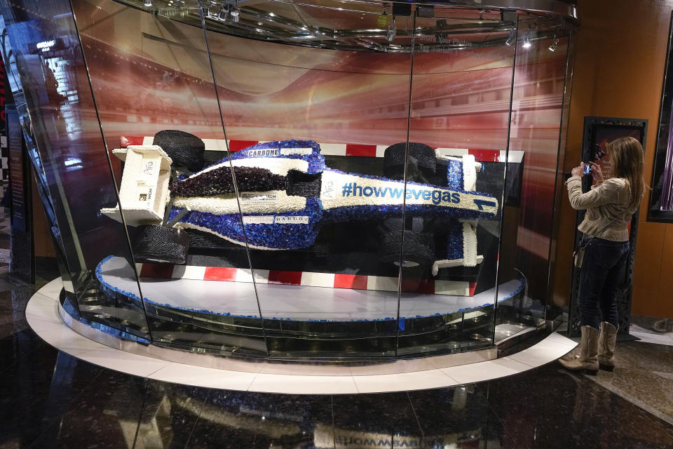 A patron takes a photo of a replica F1 car that is made of candy before the opening ceremony at the Formula One Las Vegas Grand Prix auto race, Wednesday, Nov. 15, 2023, in Las Vegas. (AP Photo/Darron Cummings)