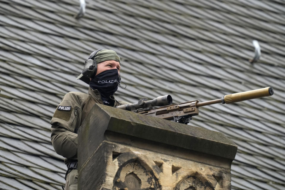 A German police officer mans an observation position from a roof ahead of a ceremony to award the International Charlemagne Prize in Aachen, Germany, Sunday, May 14, 2023. Ukraine's President Volodymyr Zelenskyy and the people of Ukraine are due to receive the International Charlemagne Prize on Sunday for contributions to European unity. (AP Photo/Michael Probst)