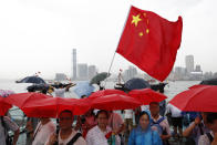 FILE - In this file photo taken Saturday, July 20, 2019, pro-China supporters hold red umbrellas and a Chinese national flag during a counter-rally in support of the police in Hong Kong. China doesn't want to intervene in Hong Kong's protests but that doesn't mean it won't, as the movement enters its seventh week. (AP Photo/Vincent Yu, File)