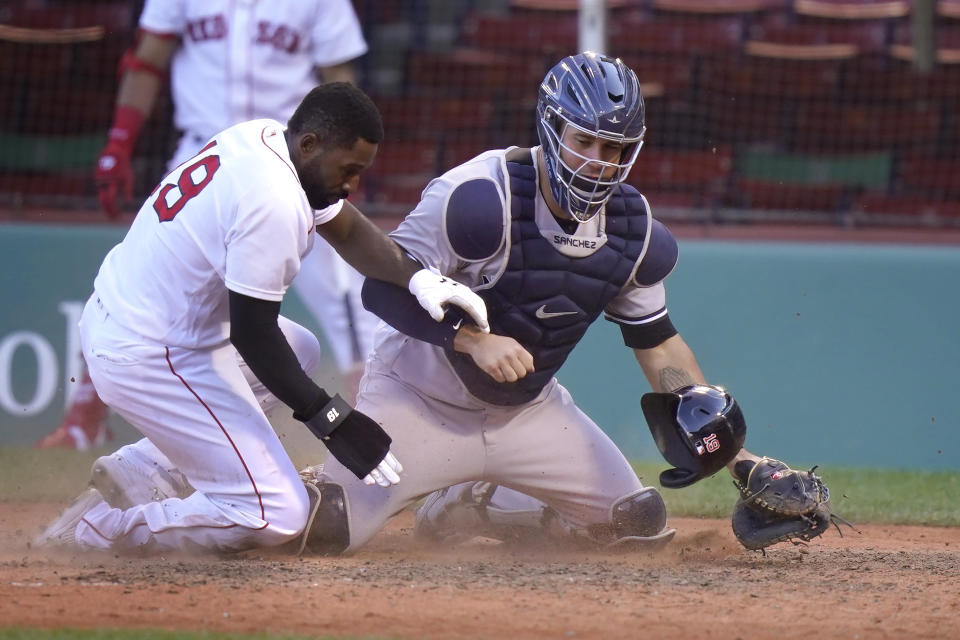 Boston Red Sox's Jackie Bradley Jr., left, scores on a sacrifice fly by Tzu-Wei Lin as New York Yankees' Gary Sanchez, right, is unable to tag him in the seventh inning of a baseball game, Sunday, Sept. 20, 2020, in Boston. (AP Photo/Steven Senne)