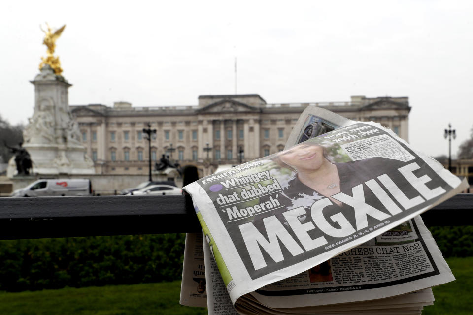 FILE - In this March 8, 2021, file photo, a newspaper is blown by the wind after it is placed on a railing by a television crew outside Buckingham Palace in London. Almost as soon as Meghan and Prince Harry's interview with Oprah Winfrey aired, many were quick to deny Meghan’s allegations of racism on social media. Many say it was painful to watch Meghan’s experiences with racism invalidated by the royal family, members of the media and the public, offering up yet another example of a Black woman’s experience being disregarded and denied. (AP Photo/Kirsty Wigglesworth, File)