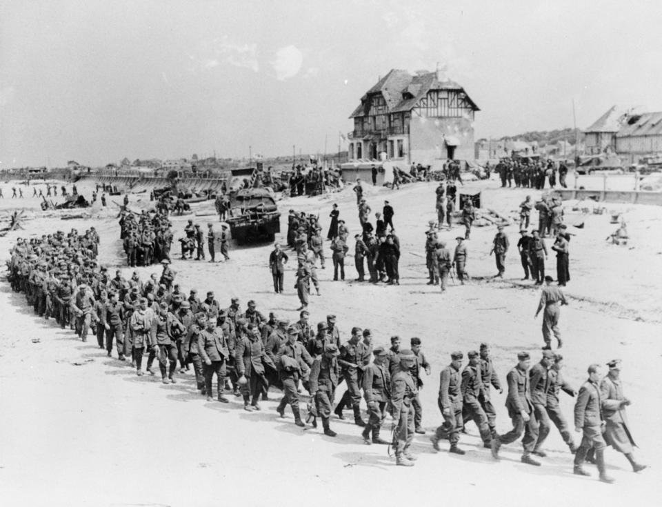 German prisoners of war march along the Juno Beach landing area to a ship taking them to England after they were captured by Canadian troops at Bernières-sur-Mer, France, on June 6, 1944. (Photo: Ken Bell/National Archives of Canada/handout via Reuters)