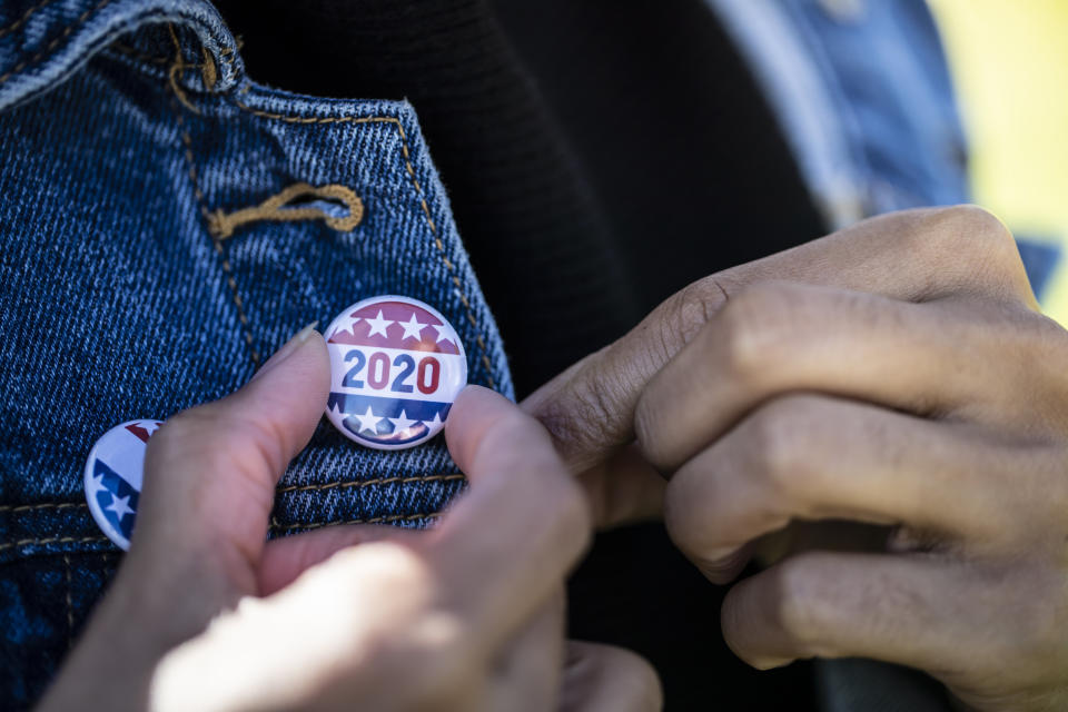 A young African American woman holding a voting badge. (Photo: LPETTET via Getty Images)