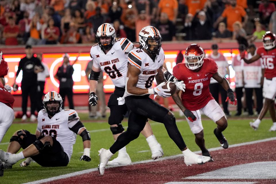 Oklahoma State running back Ollie Gordon II (0) scores a touchdown against Houston during the second half of an NCAA college football game Saturday, Nov. 18, 2023, in Houston. Oklahoma State won 43-30. (AP Photo/David J. Phillip)