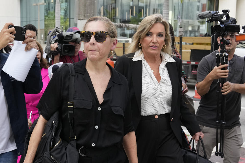 Defense lawyer Jacqueline Arango, center right, and Karla Wittkop Rocha, center left, wife of Manuel Rocha, are trailed by journalists as they leave the James Lawrence King Federal Justice Building in Miami, Monday, Dec. 4, 2023. Manuel Rocha, 73, a former American diplomat who served as U.S. ambassador to Bolivia, has been charged with serving as a secret agent for Cuba's intelligence services dating back decades, the Justice Department said Monday. (AP Photo/Rebecca Blackwell)