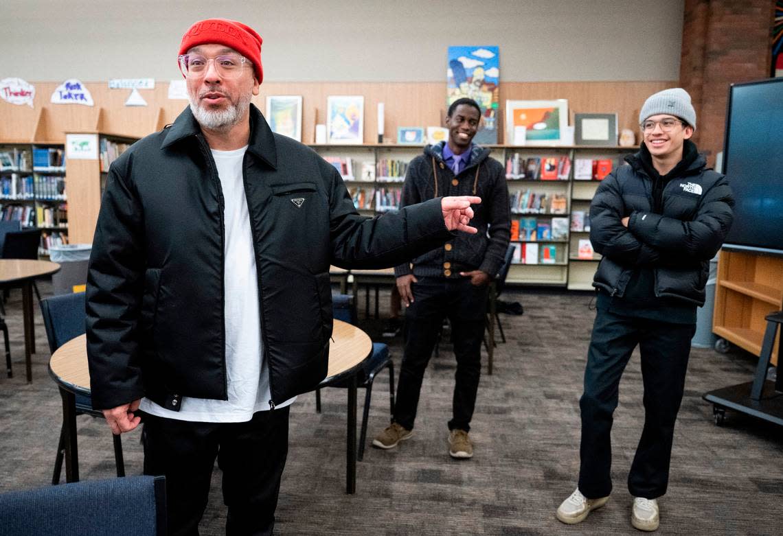 Comedian Jo Koy, left, points to his son Joe Herbert Jr., as they stand in the library during a tour of Koy’s alma mater, Foss High School on Nov. 29, 2022.