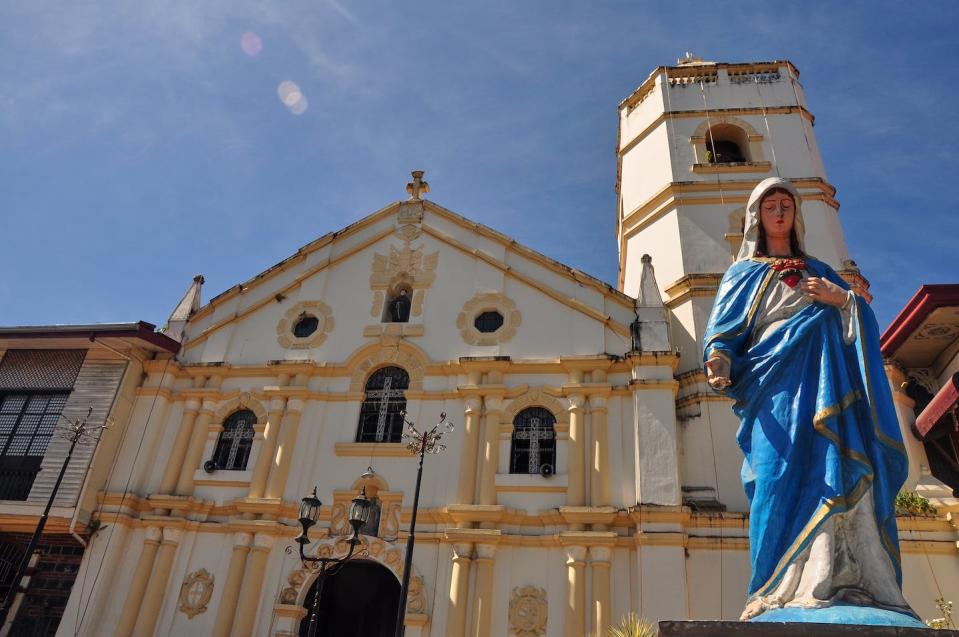 A statue of the Virgin Mary outside the Sariaya Church in Quezon Province, Philippines. <a href="https://www.gettyimages.com/detail/photo/the-virgin-mary-with-an-old-church-behind-royalty-free-image/1219146141?phrase=virgin+mary+Philippines+apparition&adppopup=true" rel="nofollow noopener" target="_blank" data-ylk="slk:Mariano Sayno/Moment;elm:context_link;itc:0;sec:content-canvas" class="link ">Mariano Sayno/Moment</a>