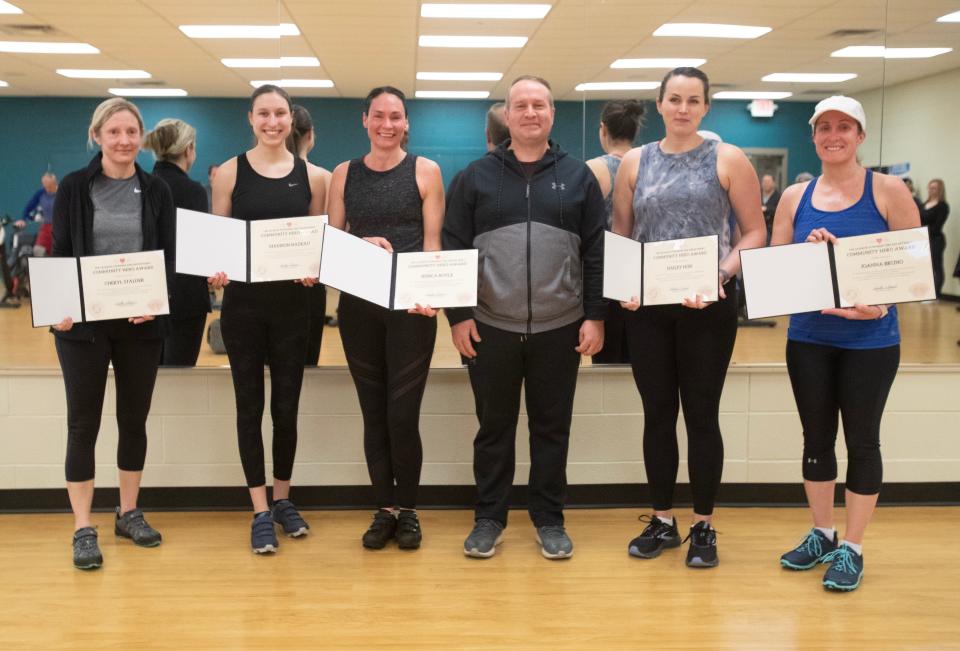 Cheryl Stalder, from left, Madison Nadeau, Jessica Boyle, Hailey Hon and Joanna Bruno pose with Joey Mohr on Saturday. Their quick actions in February saved his life during a cardiac episode at a Paul and Carol David YMCA spin class.