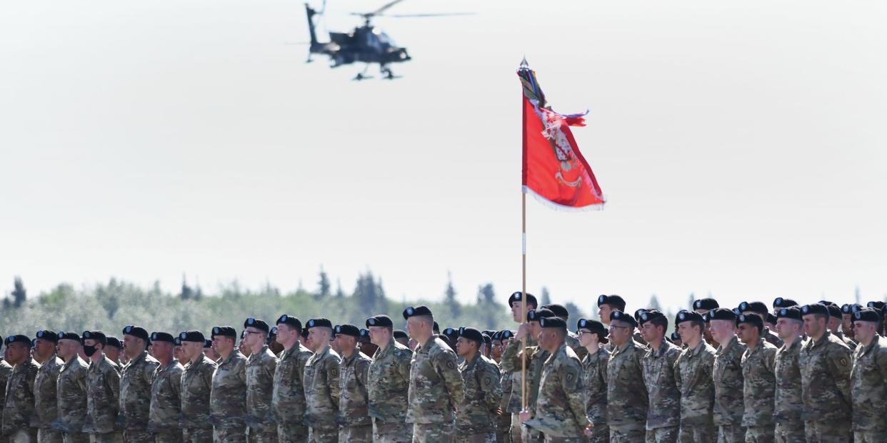 AH-64 Apache helicopter flies over soldiers in Alaska