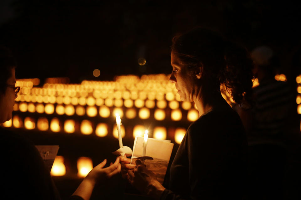 Members of the public hold a candles near luminaries that mark the graves of Union dead at Soldiers' National Cemetery during ongoing activities commemorating the 150th anniversary of the Battle of Gettysburg, Sunday, June 30, 2013, in Gettysburg, Pa. Union forces turned away a Confederate advance in the pivotal battle of the Civil War fought July 1-3, 1863, which was also the war’s bloodiest conflict with more than 51,000 casualties. (AP Photo/Matt Rourke)