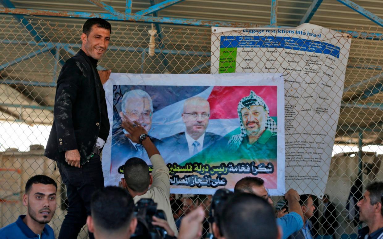 Posters of Palestinian Authority leaders were hung up at the border crossings after Hamas handed over control - AFP