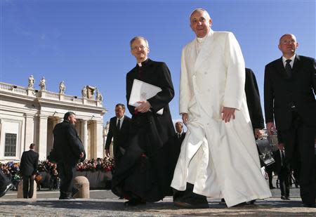 Pope Francis walks as he arrives to lead the general audience in Saint Peter's Square at the Vatican March 5, 2014. REUTERS/Alessandro Bianchi